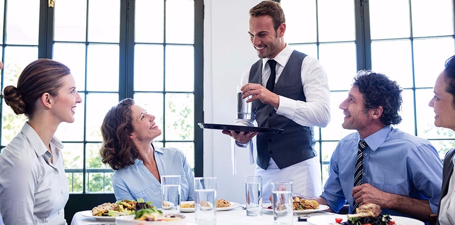 Waiter serving customers in a restaurant