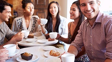 Group of friends enjoying coffee & cake in a coffee shop